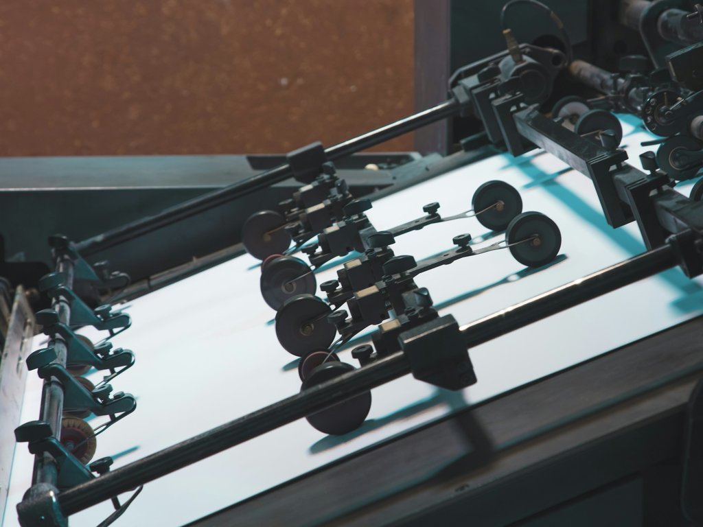 Detailed view of an industrial printing machine showcasing parts and rollers in action.